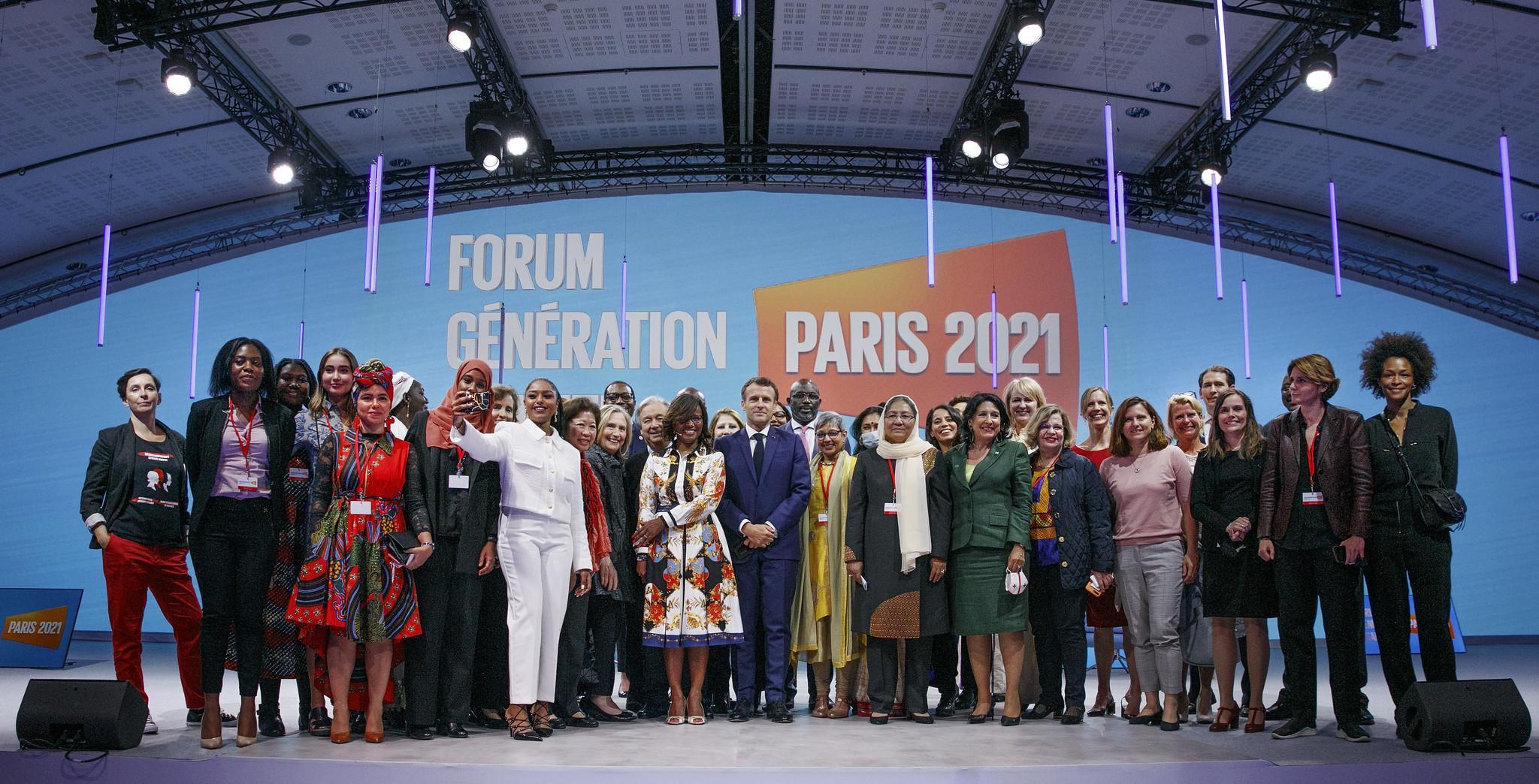 Suuri joukko päättäjiä, aktivisteja ja yrittäjiä seisoo yhdessä lavalla. Taustalla näkyy Pariisin tasa-arvofoorumi -teksti.